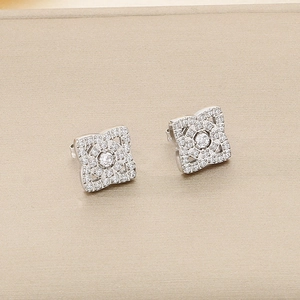 Détail macro de boucles d'oreilles cœur en argent avec zircons sur boîte beige