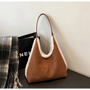 Detailed close-up of brown suede tote bag with white plush fleece trim and leather strap