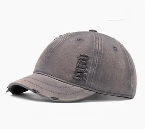 Close-up of washed gray baseball cap showing vintage distressed edge and ripped details