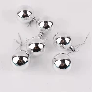 Close-up of five silver mirror finish Christmas ball ornaments with hanging strings