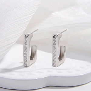 Macro shot of silver S925 sterling silver U-shaped earrings with zircon inlay and hallmark