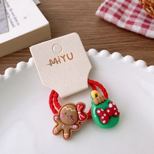 Detail of Christmas hair tie with gingerbread man and festive bauble on a display card