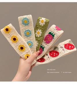 Detail of five crochet knit headbands with sunflower, daisy, and strawberry patterns