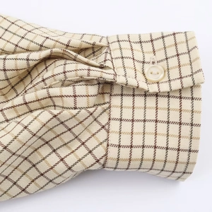Classic plaid cotton-linen blend shirt cuff with beige button detail on a white background
