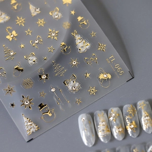 Golden Christmas nail art stickers featuring snowflakes and trees on grey manicure