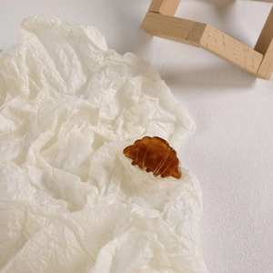 Gros plan d'une pince à cheveux en résine ambrée en forme de croissant rustique