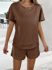 Detail of brown knit two-piece lounge set with geometric textured fabric pattern