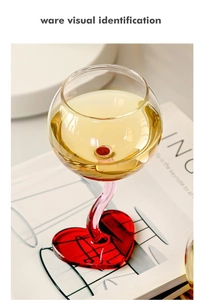 Detail of pink curved glass stem and red heart base of the romantic wine goblet