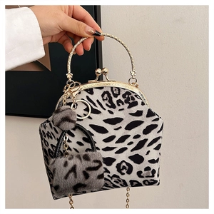Detailed close-up of leopard print shell bag with gold metal handle and mini charm