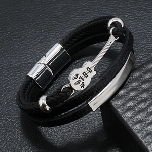 Macro shot of multilayer black leather bracelet featuring a silver guitar charm and beads