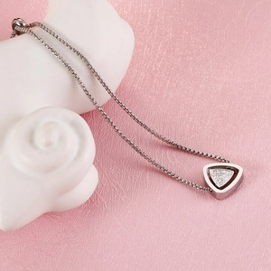 Vue détaillée du collier en acier titane argenté avec un pendentif géométrique double triangle