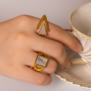 Retro stainless steel gold ring set with geometric white shell inlay worn by a model