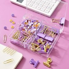 Close-up of purple and gold stationery set including binder clips and paper clips