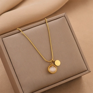 Collier élégant en titane doré avec pendentif rond en pierre œil-de-chat sur écrin à bijoux