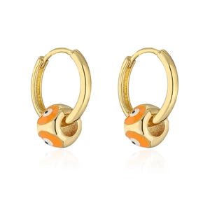 Detail of gold plated hoop earrings featuring a vibrant orange evil eye enamel bead charm