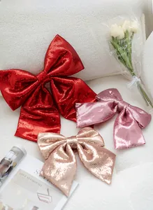 Macro detail of large pink and red sequin bows for Christmas tree decoration with shimmer
