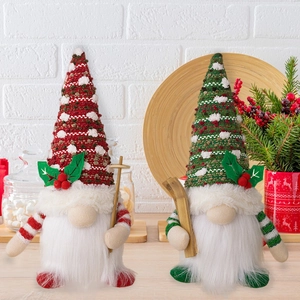 Set of two glowing Christmas gnomes with knit hats and wooden skis on a cozy table