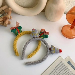 Detail of plush Christmas headbands featuring festive reindeer and gift box decorations