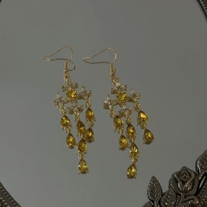 Detail of vintage gold tassel earrings featuring amber teardrop stones and starburst accents