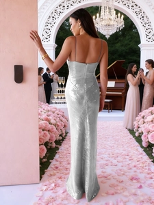 Robe à paillettes argentée avec dos nu et coupe ajustée devant une arche fleurie chic