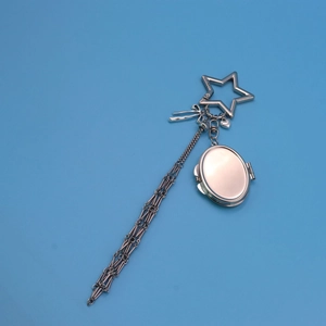 Detail of silver star keychain with metal tassels, heart charm and locket pendant