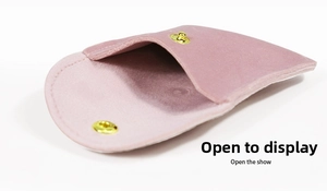 Detailed open view of a pink velvet jewelry pouch with golden snap button closure