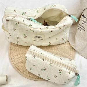 Close-up of quilted floral cosmetic bag set with zipper details and ribbon pullers