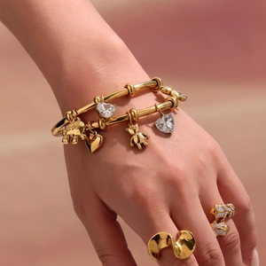 18k gold plated stainless steel jewelry set with elephant and bear charms on a bangle