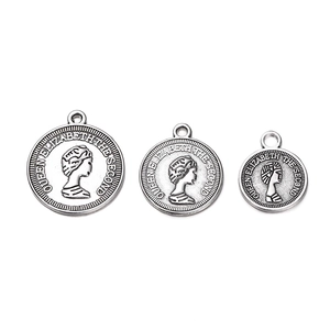 Detailed view of three silver alloy Elizabeth II coin charms in varying sizes for jewelry