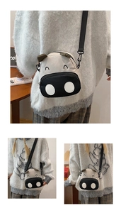 Detail view of mini cow-shaped canvas crossbody bag with cute embroidery and strap