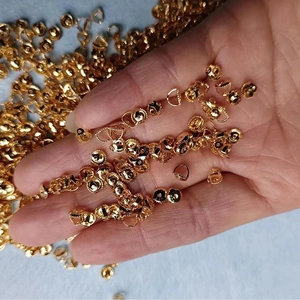 Macro view of gold-plated earring backs held by hand for jewelry making diy