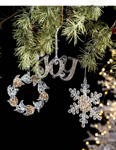 Macro detail of acrylic gold glitter JOY, wreath and snowflake Christmas tree ornaments