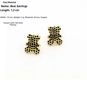 Detail shot of bear stud earrings in copper with 18k gold plating and black cubic zirconia