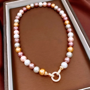 Close-up of pearl necklace with multicolored beads and crystal-encrusted gold clasp