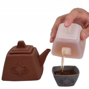 Action shot of heat resistant silicone teapot pouring tea into a matching cup