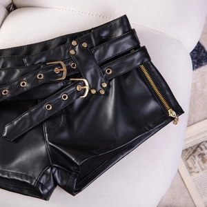 Detailansicht der schwarzen PU-Ledershorts mit goldenen Nieten und seitlichen Reißverschlüssen