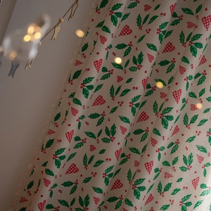 Christmas curtain with red plaid hearts and green holly leaves with festive tassels