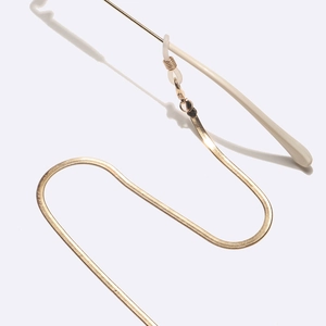 Detail of golden flat snake chain for eyewear with transparent silicone connector ends