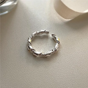 Detailed view of handmade 925 sterling silver knotted twist ring on silk background
