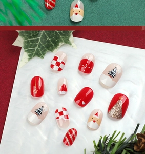 Detailed view of Christmas press-on nails featuring Santa, glitter, and festive patterns