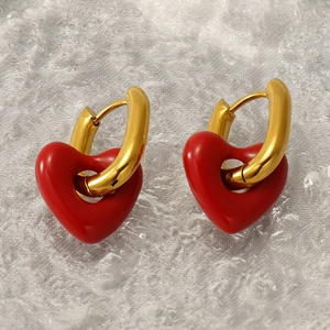 Detailed view of gold hoop earrings featuring a vibrant red 3D hollow heart pendant
