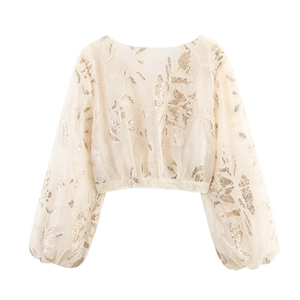 Close-up of beige mesh top with gold sequin embroidery and elegant lantern sleeves
