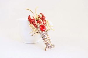 Macro detail of a crystal-encrusted lobster keychain charm with red and white rhinestones