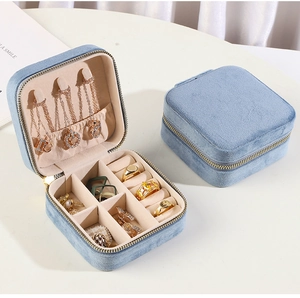 Detail view of open and closed light blue velvet jewelry boxes with multiple compartments