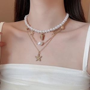 Detail view of multi-layer ocean necklace with starfish, seashell pendants and pearls