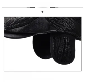 Dettaglio del cappello in pelle nera con paraorecchie e trama in rilievo fine