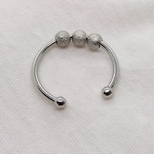 Close-up of rotatable frosted silver beads on a stainless steel open fidget ring