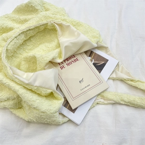 Detailed macro view of the soft yellow bubble pleated texture and inner lining of the tote