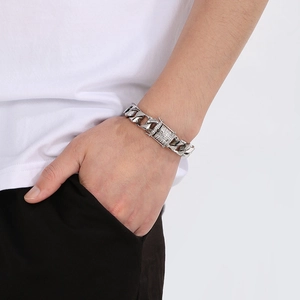 Close-up of silver Cuban link bracelet with diamond-encrusted clasp on a male wrist
