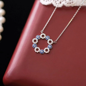 Vue macro du collier œil maléfique avec émail bleu et cristaux sur boîte en cuir